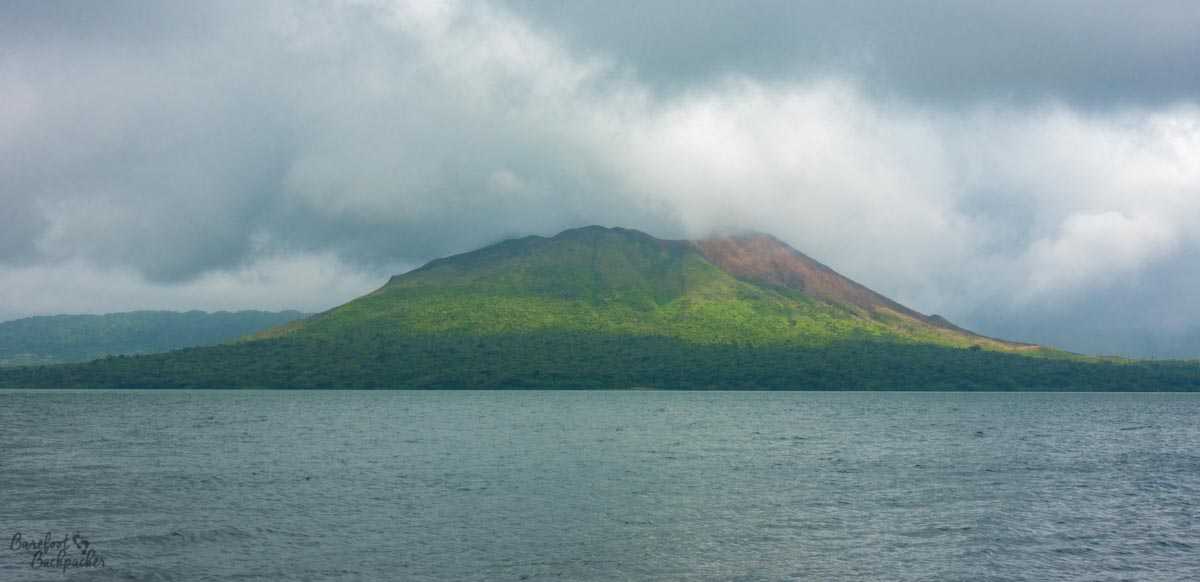 Mount Garet, Gaua, as seen across Lake Letas, cloudy.