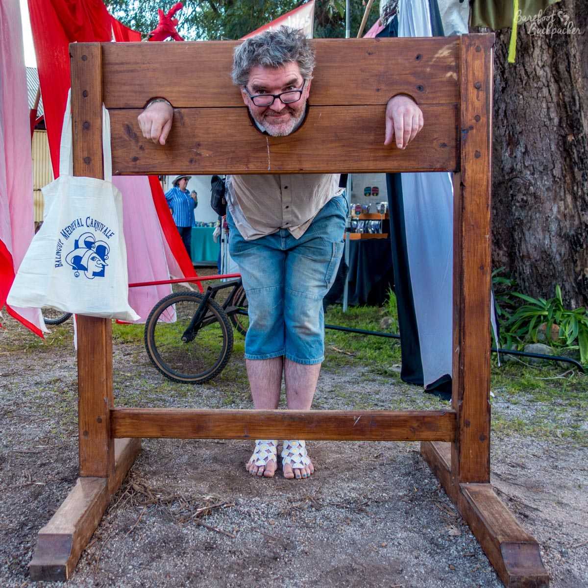 The Barefoot Backpacker locked in a pillory, Mediaeval Carnivale, Balingup