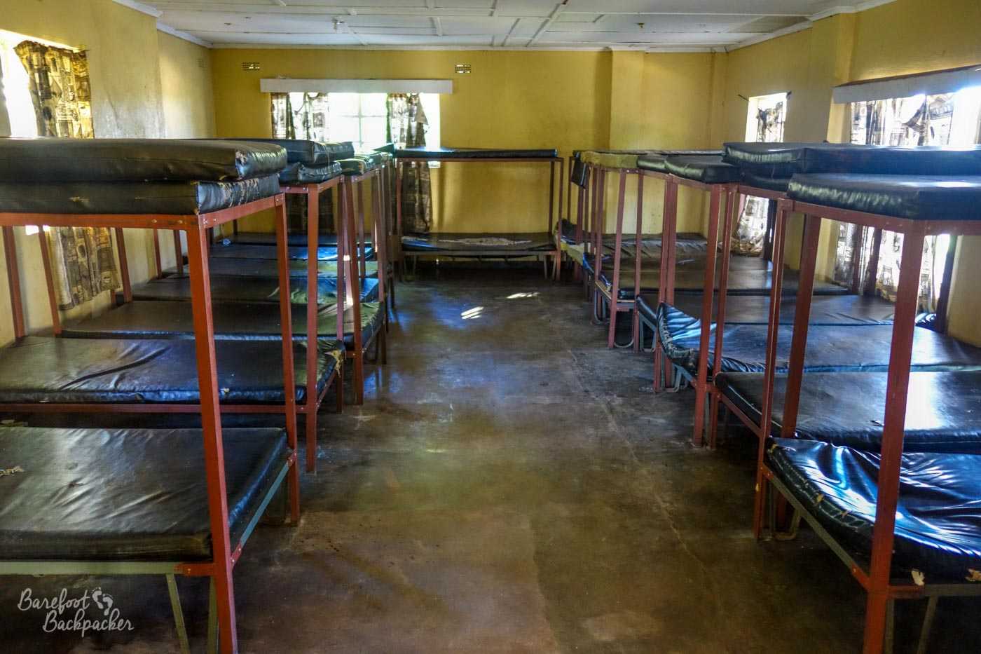 The empty, austere, minimalist, dorm room – the cheapest accommodation available. There's 28 beds in shot, in very close-fitting metal two-bunk beds, and there's a smaller room behind the camera with four more bunks.