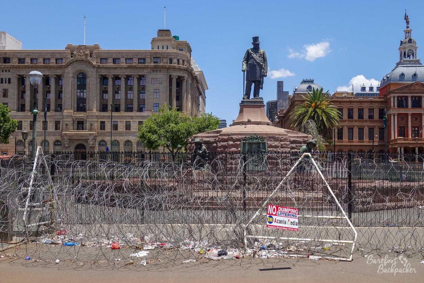 The Paul Kruger statue in the centre of Pretoria, surrounded by barbed wire and lots of litter