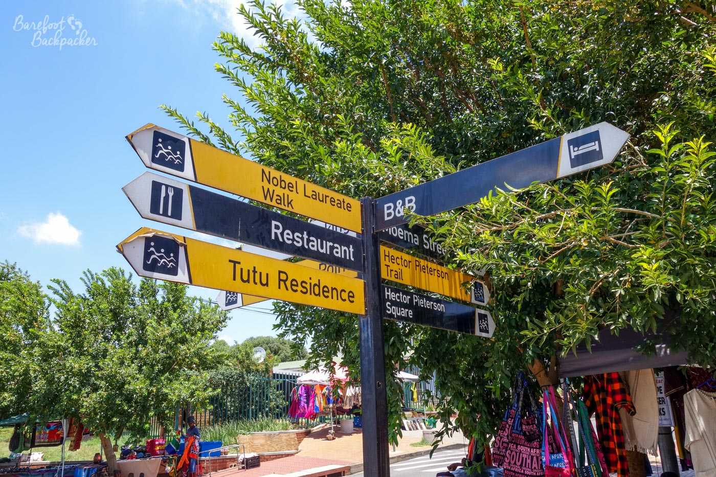 Signpost in central Soweto showing directions to Tutu's House and Hector Pieterson Memorial, amongst other things