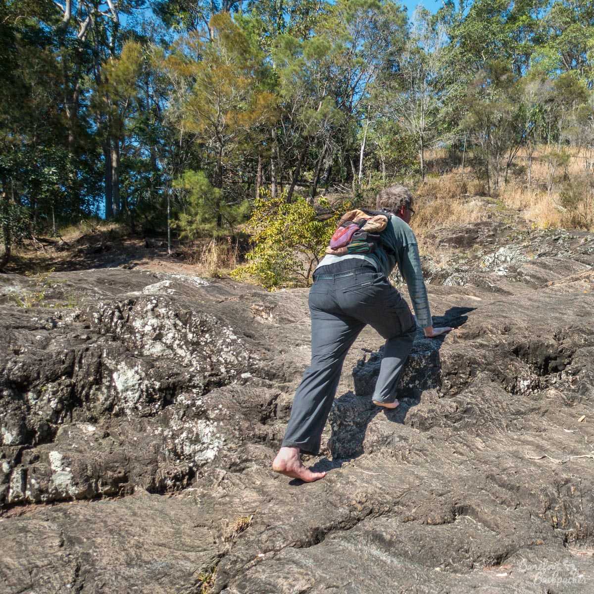 Rock-climbing barefoot, at a waterfall near Nambour, Australia
