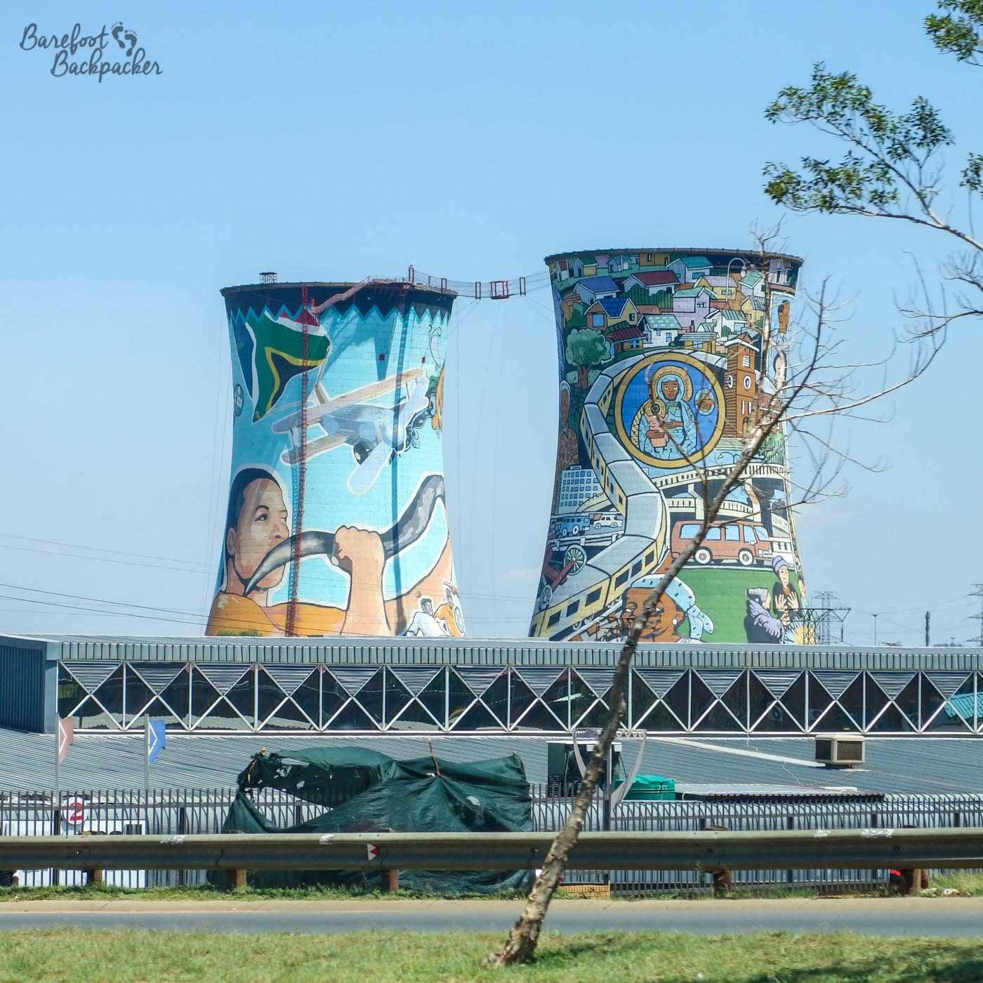 Orlando Power Station cooling towers, in Soweto, adorned with murals. The bungee platform is visible between them.