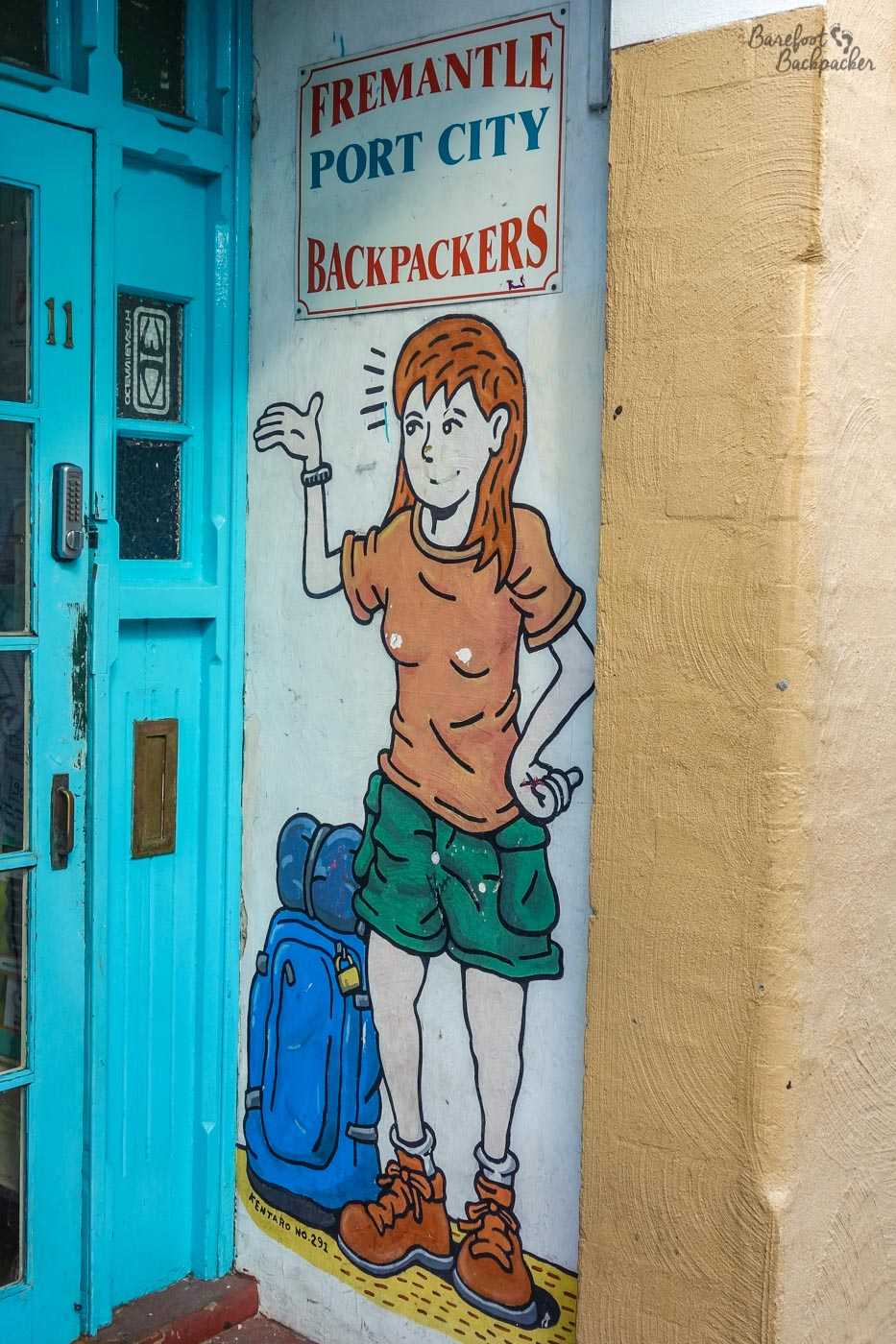The doorway to the Pirate Backpackers Hostel in Fremantle. There's a cartoonish image of a woman in t-shirt, shorts, and boots, bag on the floor by her feet. It looks nothing like me but maybe I like to think it should? Apart from the boots, obviously.