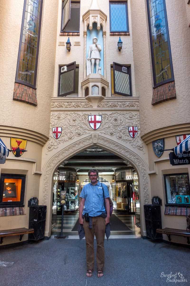 Scene in London Court; I'm standing in front of one of the entrance towers. It's tall and pointed, like a castle gateway.
