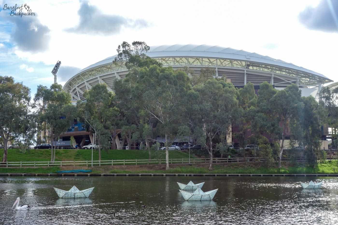 The Adelaide Oval cricket and AFL ground, as seen from the opposite side of the river. It's round, with a kind of raised roof that makes it look not a little like a parked alien spaceship.
