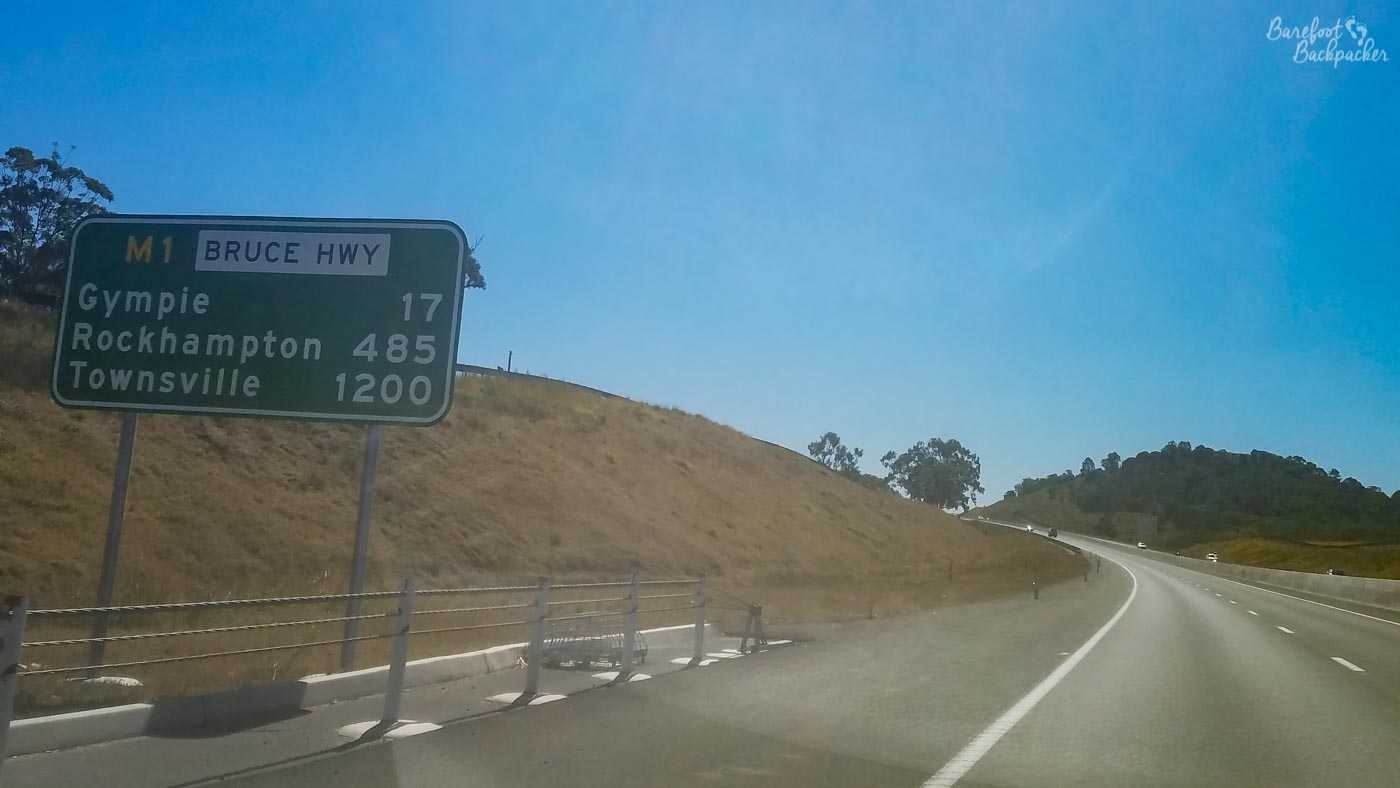 Picture taken from inside a car of a signpost on the (M1) Bruce Highway. Gympie is 17km; Rockhampton 485km; Townsville 1,200km. Australia is big.
