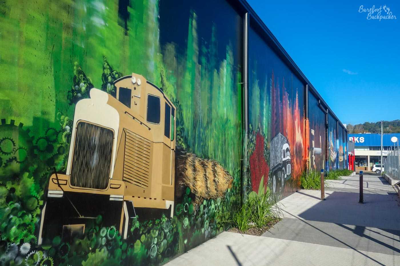 Mural on a wall in Nambour, depicting part of the history of the town. This section shows the big farming equipment used to harvest the sugar cane.