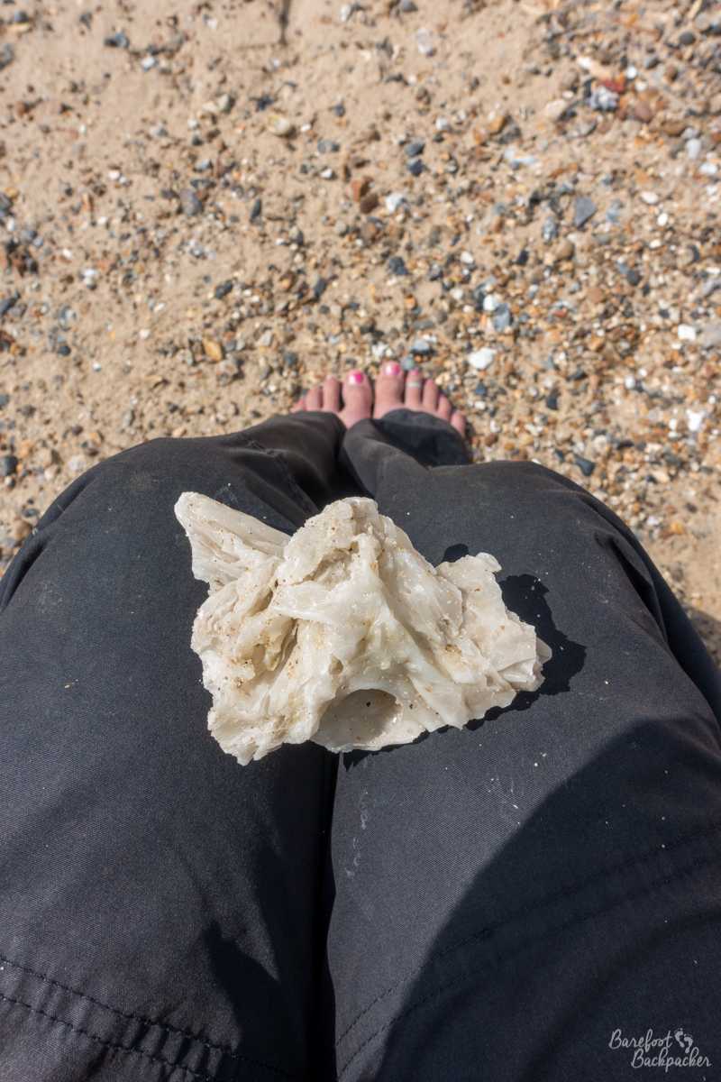 A lump of palm oil rests on my lap, as I sit on the slightly shingle beach. It's got the look of a jagged piece of quartz rock, and is maybe the size of my palm. It has the feel of butter.