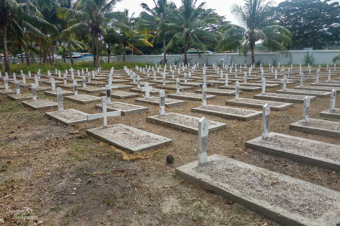 A graveyard in Dili, part of Santa Cruz cemetery. Each grave is a simple rectangular slab of stone with a plain cross at one end.