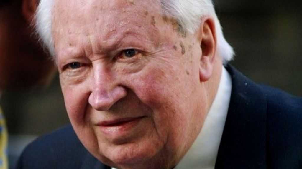 An image of Edward Heath. He's old, white, grey hair, and wearing a suit. It's an image that's a close up of his face
