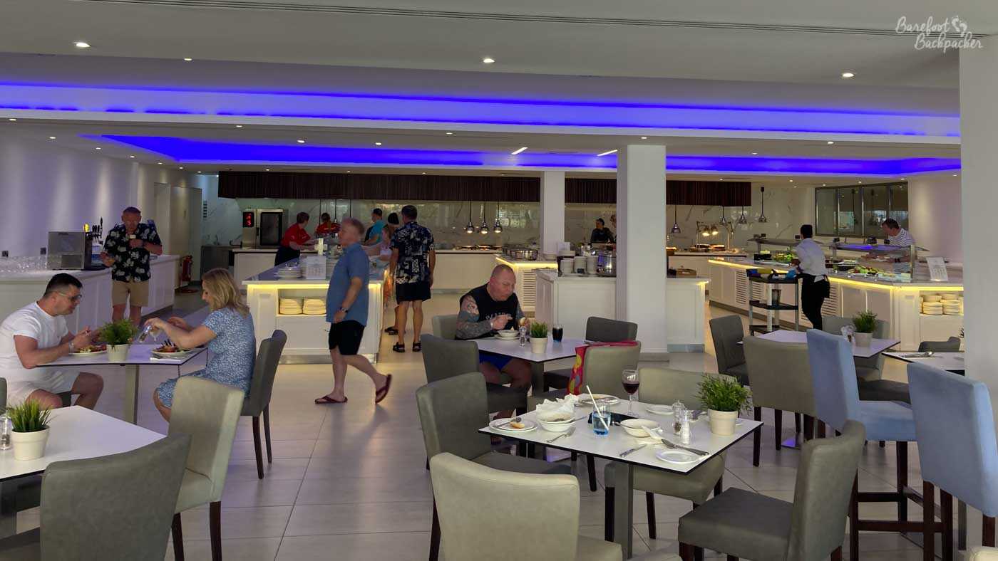 Wide overview of one of the buffet restaurants in the St George Hotel, which is freely accessible an the all-inclusive resort package. There's four banks of food in three columns and a back row, with fluorescent lighting above