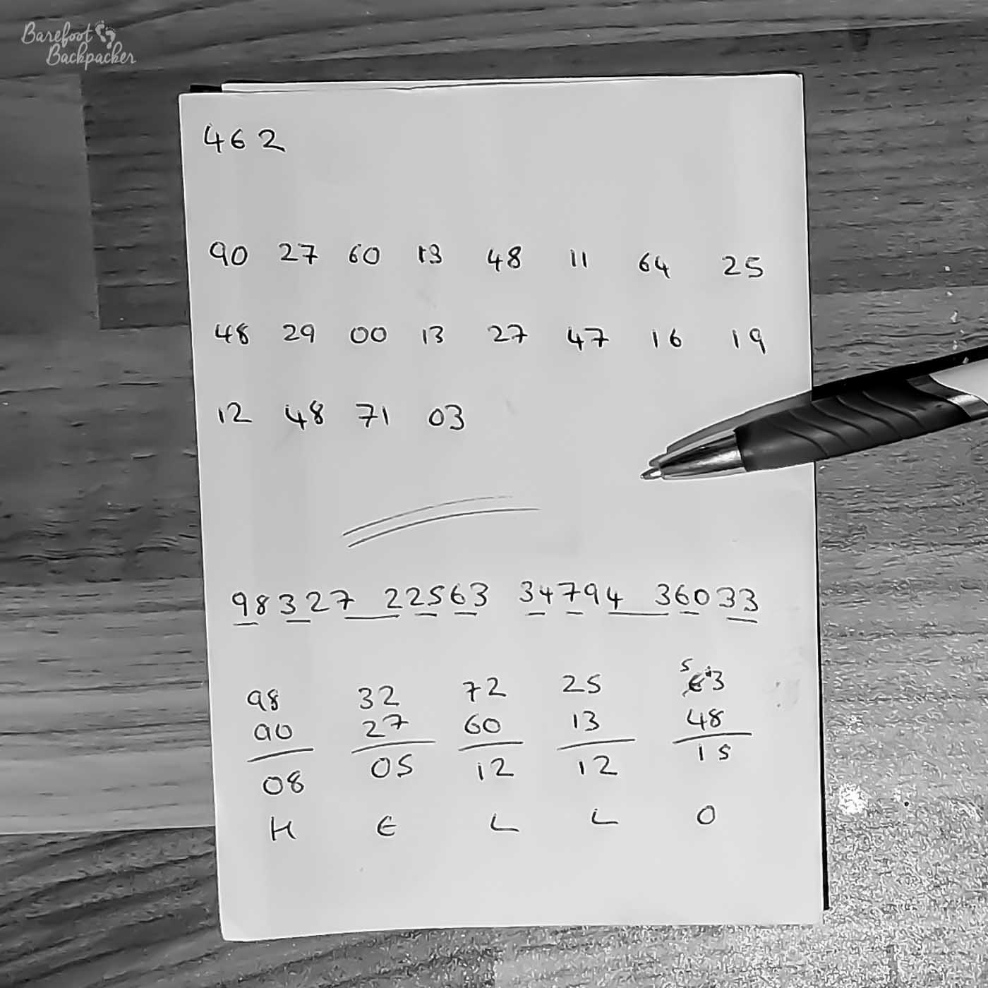 Image of a sheet of paper on a table with a summary of the above steps on it – the long key code from step 2 at the top, separated out into two-digit numbers, then below that the message transmitted at step 6, and below that a series of sums calculated in step 7 to produce the word 'hello'.
